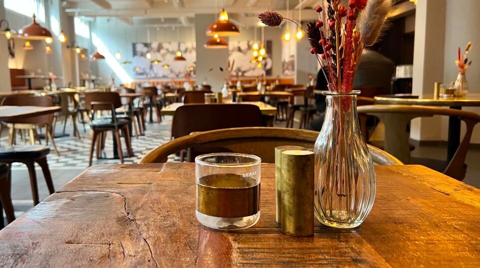 Julefrokost i Rådhuskælderen — bord med stearinlys og blomster